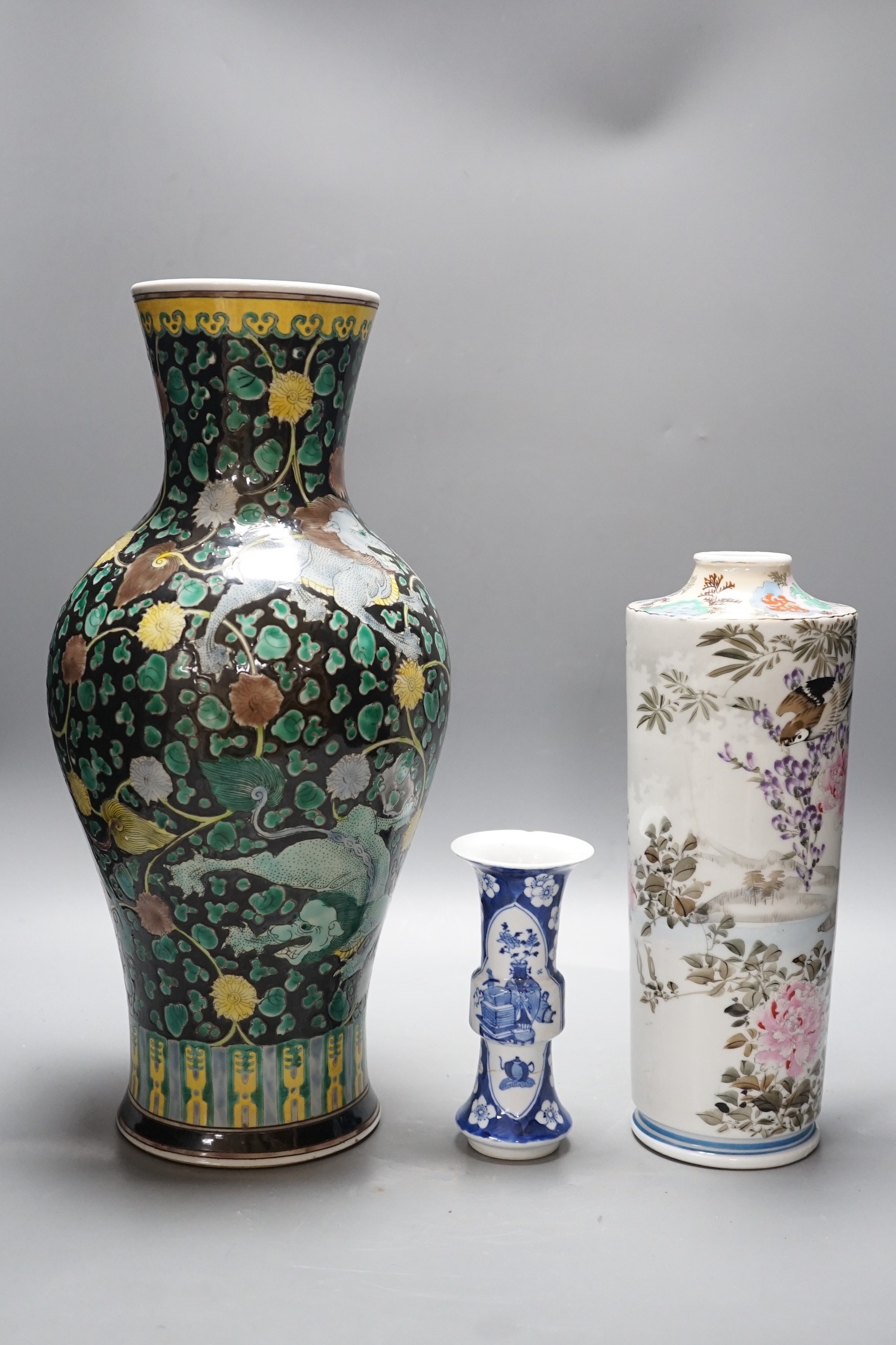 A Chinese famille noire vase, a Chinese blue and white small gu vase and a Japanese cylindrical vase, tallest 43cms high